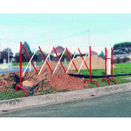 Photo de mise en situation de la barrière extensible pour travaux temporaire en extérieur devant un trou creusé dans le sol.
